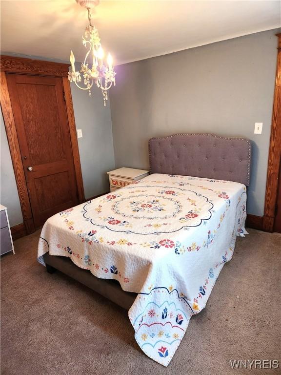 carpeted bedroom with a chandelier and a closet