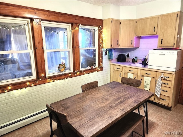 kitchen featuring a textured ceiling, a baseboard heating unit, and light countertops