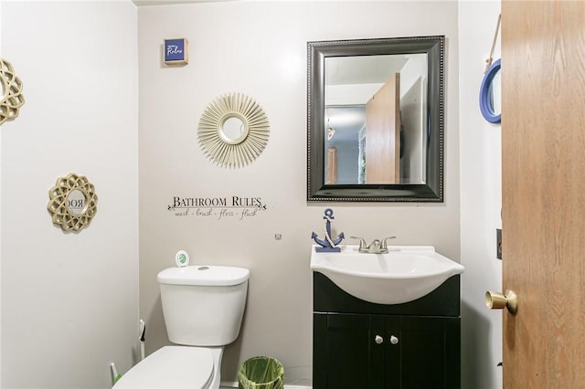 half bathroom with vanity and toilet