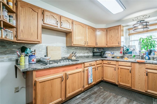 kitchen featuring tasteful backsplash, stainless steel gas cooktop, and dark wood finished floors