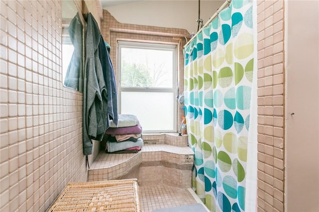 full bathroom featuring a shower with shower curtain and tile walls