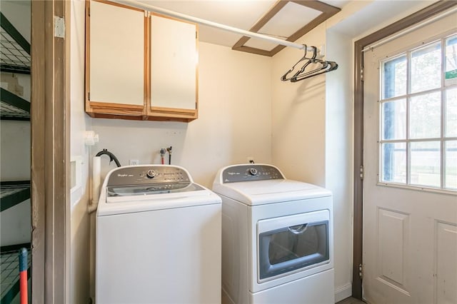 washroom featuring washer and clothes dryer, cabinet space, and a wealth of natural light