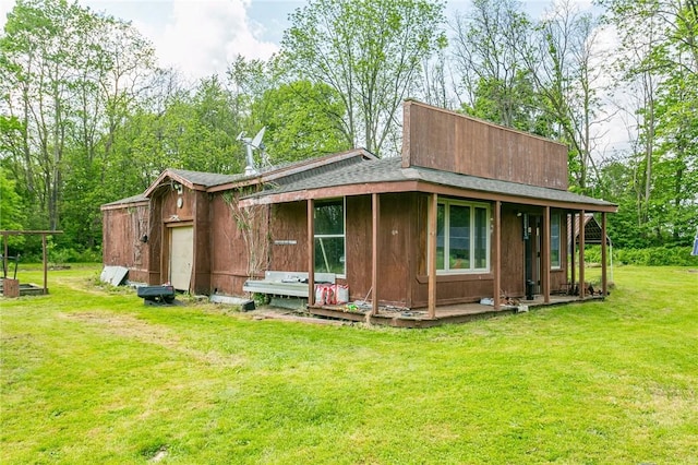 rear view of property featuring a garage and a yard