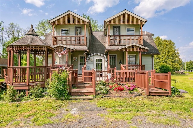 view of front of house featuring a gazebo, roof with shingles, and a balcony