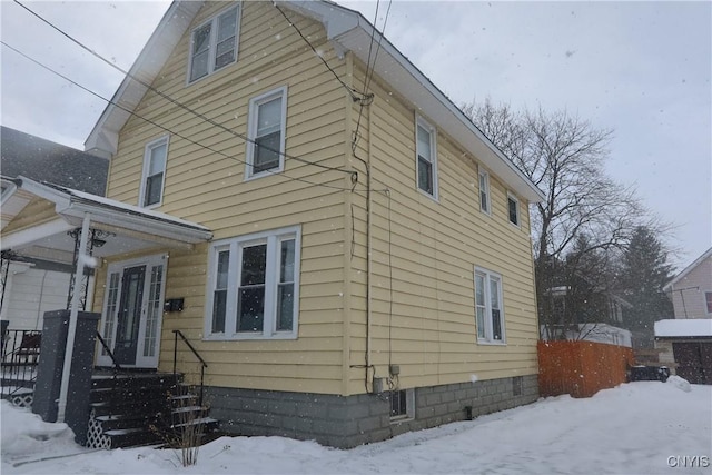 snow covered property featuring entry steps