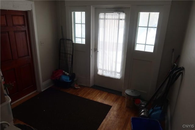 doorway with plenty of natural light, wood finished floors, and baseboards