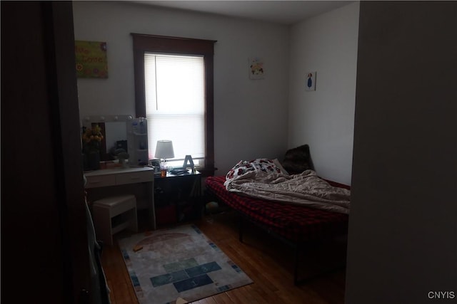 bedroom with wood finished floors and multiple windows