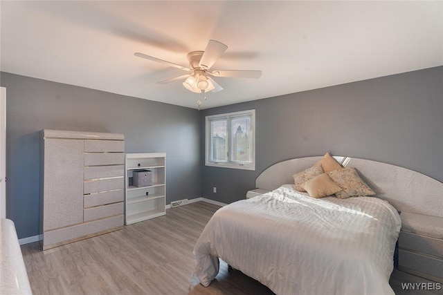 bedroom with visible vents, ceiling fan, baseboards, and wood finished floors