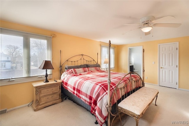 bedroom with ceiling fan, multiple windows, baseboards, and light colored carpet