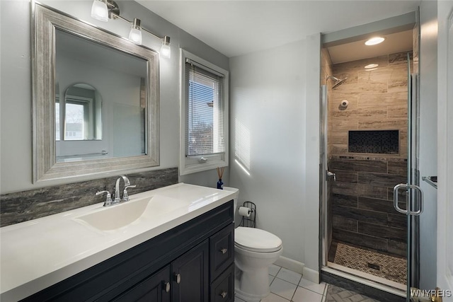 bathroom with vanity, plenty of natural light, a shower stall, and toilet