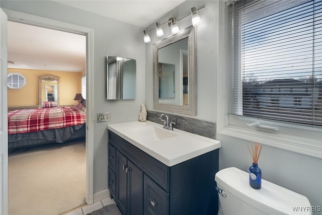 ensuite bathroom with ensuite bathroom, toilet, and vanity