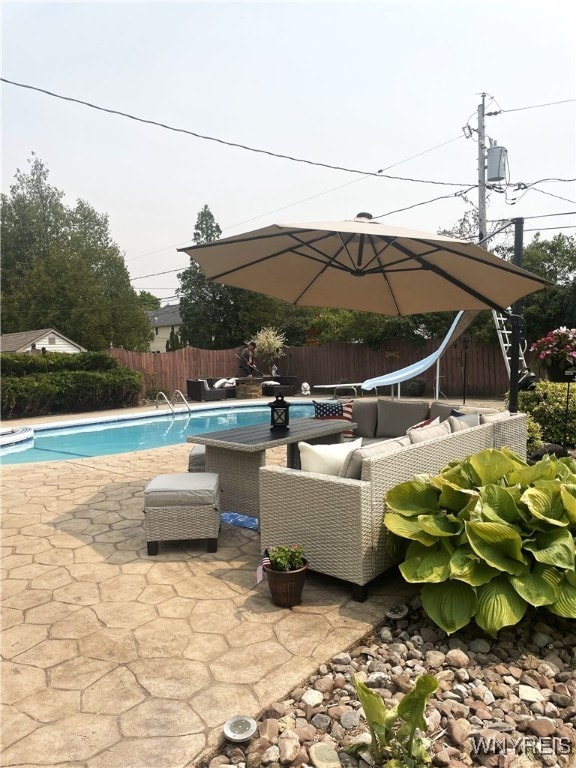 view of pool with a fenced in pool, a patio, a water slide, a fenced backyard, and an outdoor living space