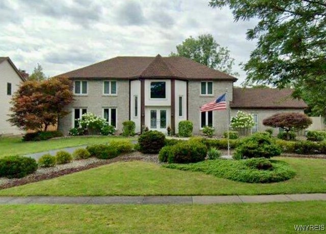 view of front of property with french doors and a front lawn