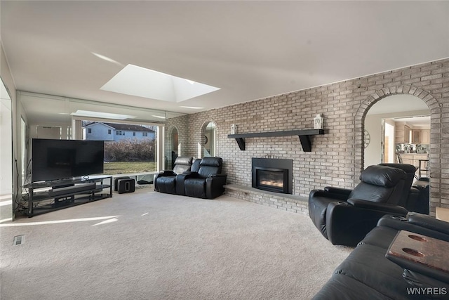 living area featuring a brick fireplace, brick wall, visible vents, and carpet flooring