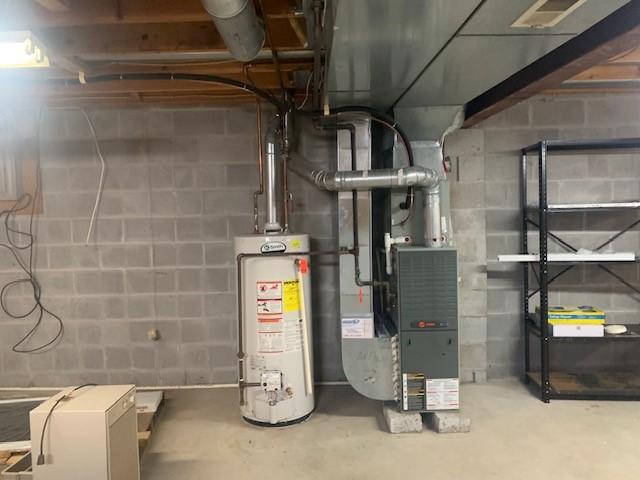 utilities featuring water heater, visible vents, and heating unit