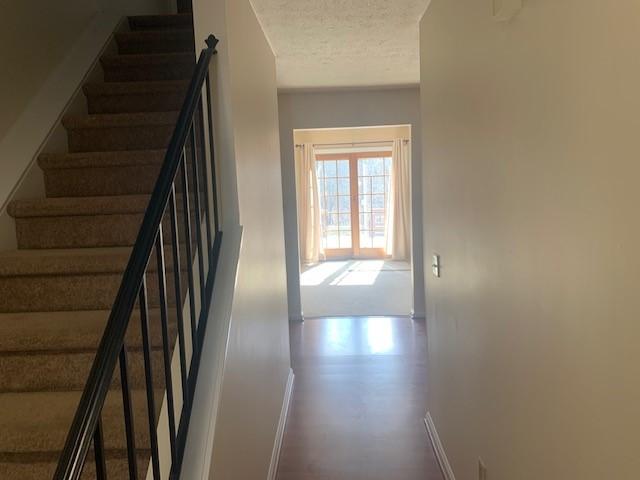 stairs with baseboards and a textured ceiling