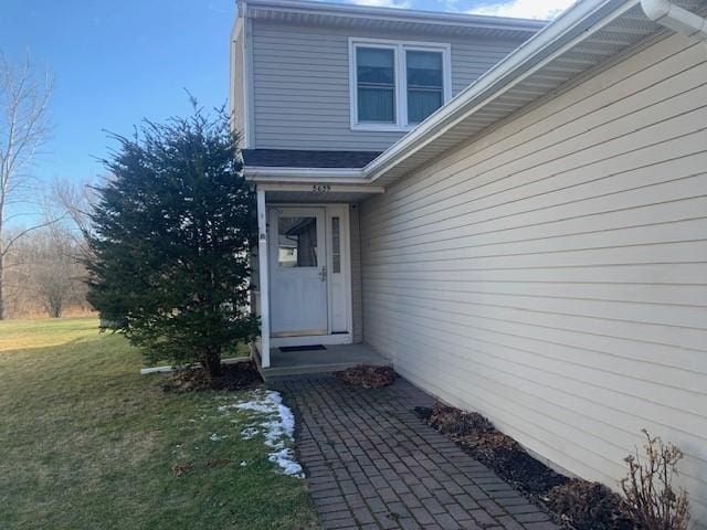 property entrance with a lawn