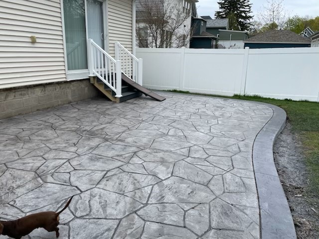 view of patio with entry steps and fence