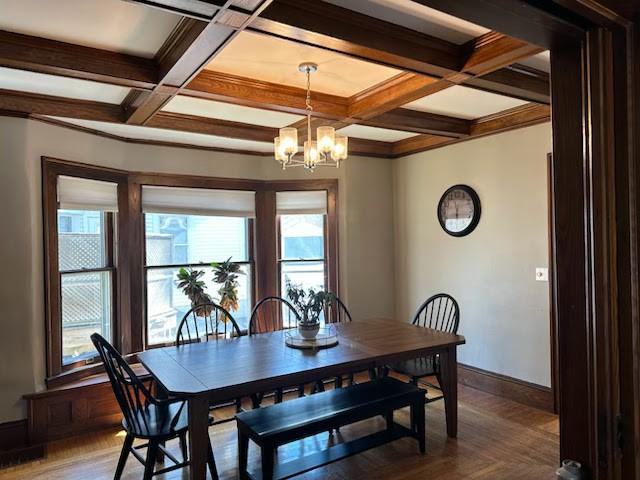 dining area featuring beam ceiling, an inviting chandelier, coffered ceiling, and baseboards