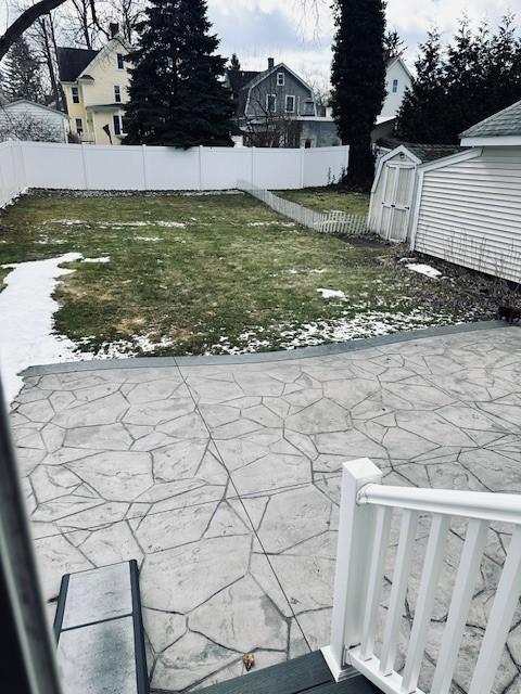 view of yard featuring a fenced backyard, a shed, and an outdoor structure