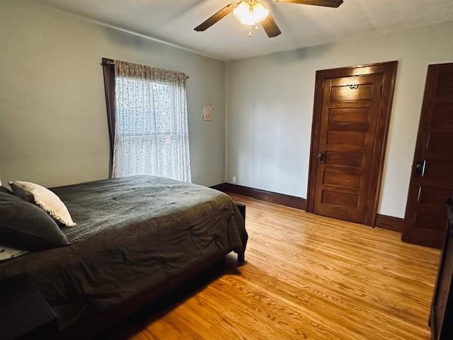 bedroom with baseboards, ceiling fan, and light wood finished floors