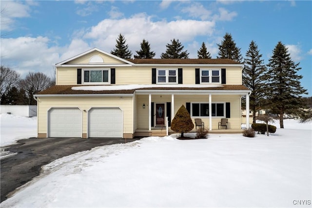 traditional-style house with covered porch, aphalt driveway, and an attached garage