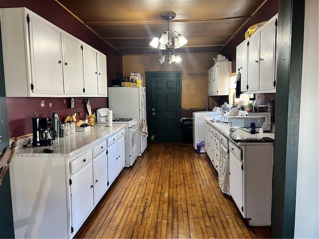 kitchen with white cabinets, dark wood finished floors, decorative light fixtures, white gas range, and a notable chandelier