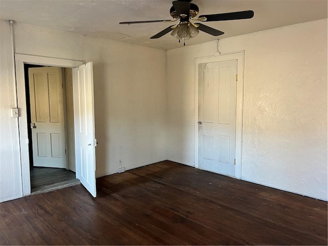 spare room featuring ceiling fan, a textured wall, and wood finished floors