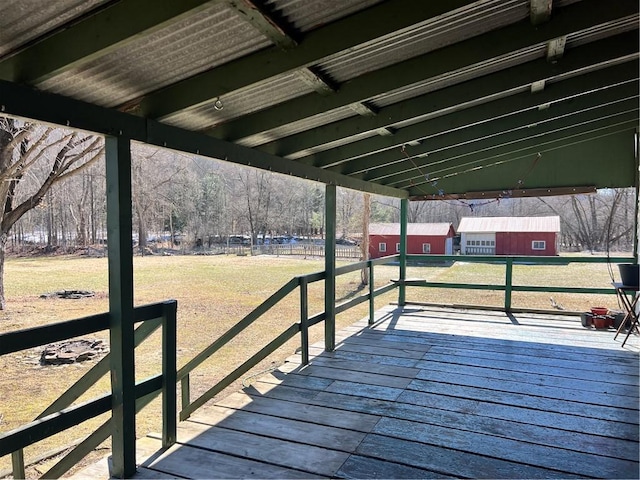 deck with a carport, an outbuilding, and a yard