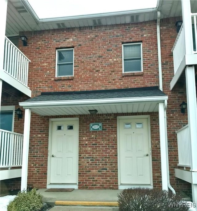 view of exterior entry featuring brick siding