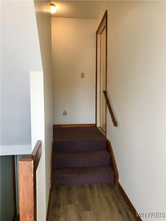 stairs with wood finished floors and baseboards