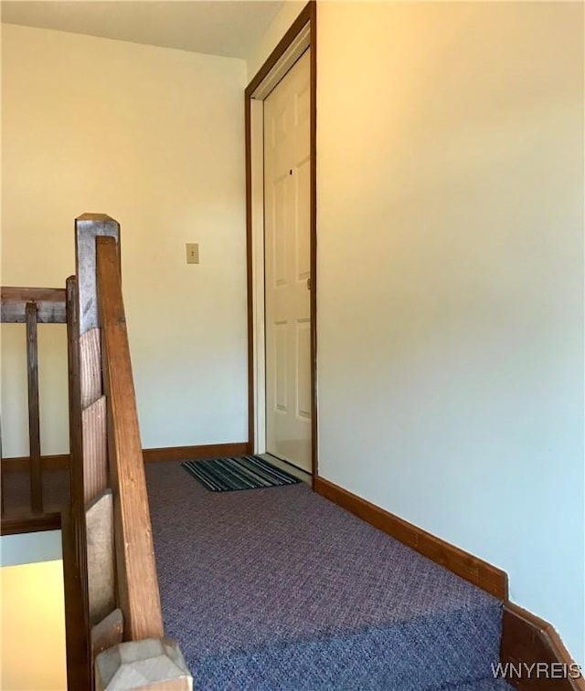 corridor with carpet and baseboards