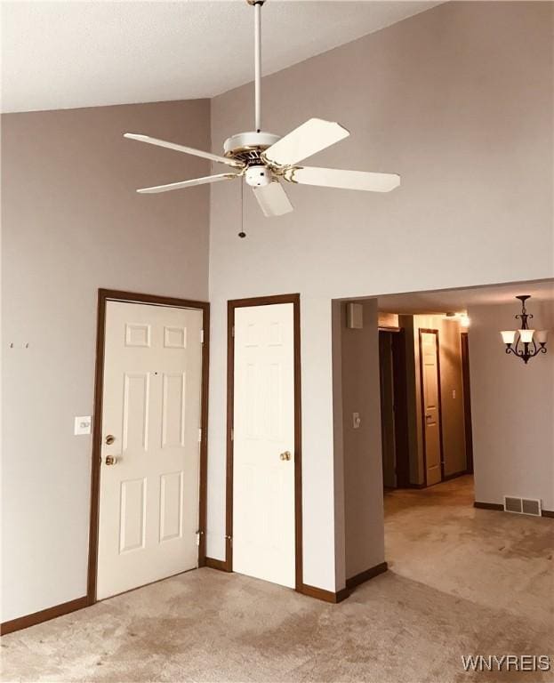 unfurnished bedroom with light carpet, visible vents, high vaulted ceiling, and baseboards