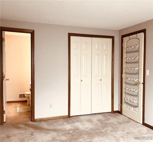 unfurnished bedroom with a closet, visible vents, baseboards, and carpet