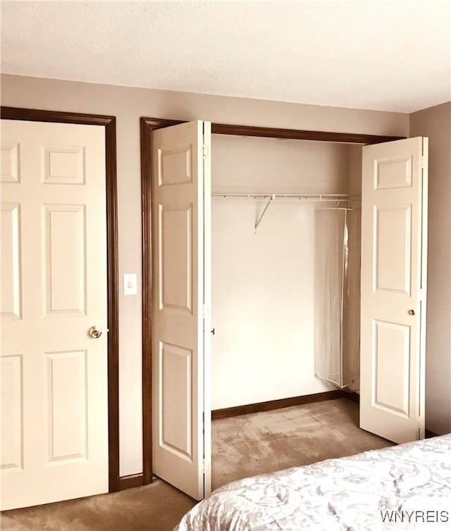 unfurnished bedroom featuring a closet, carpet flooring, and baseboards