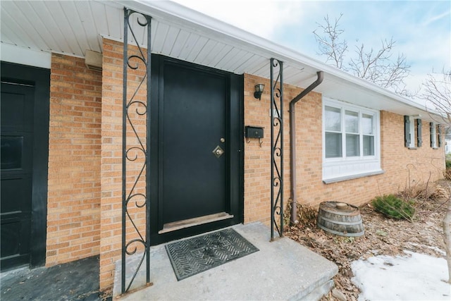 view of exterior entry featuring brick siding