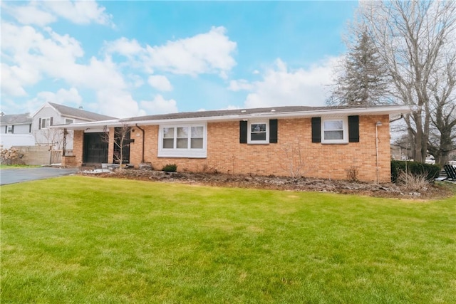 single story home with brick siding, driveway, an attached garage, and a front lawn