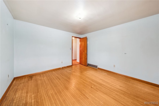 unfurnished room with light wood-style flooring, baseboards, and visible vents