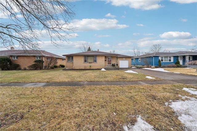 single story home featuring aphalt driveway, a garage, and a front lawn