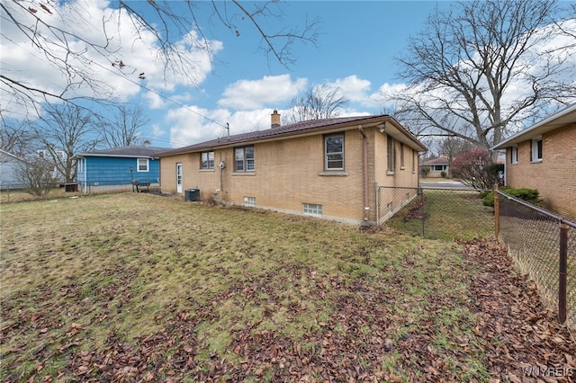 rear view of property with brick siding, a lawn, cooling unit, a chimney, and a fenced backyard