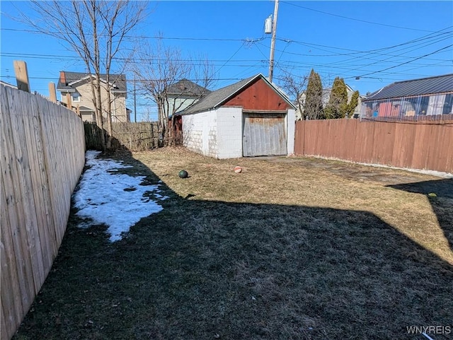 view of yard with an outbuilding, a fenced backyard, and a shed