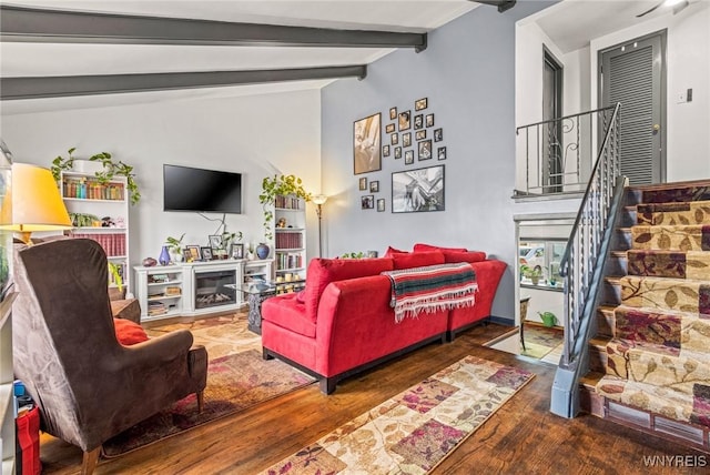 living area featuring stairway, vaulted ceiling with beams, and wood finished floors