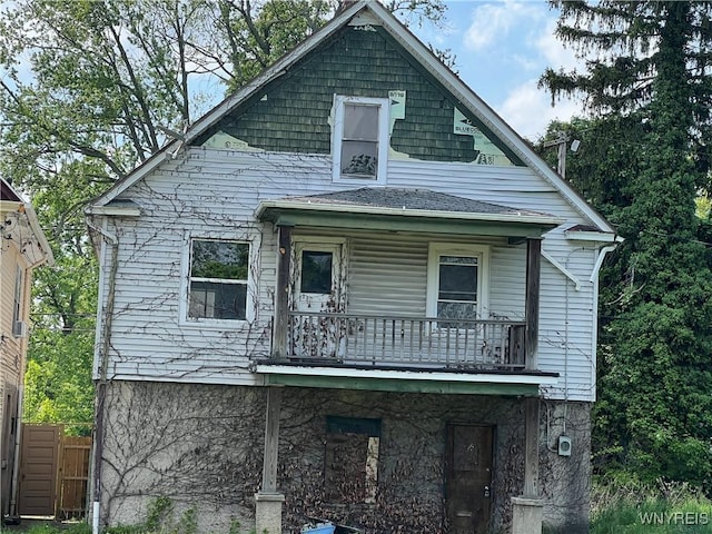 view of front of property featuring a balcony and fence