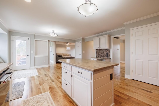 kitchen featuring light wood-style floors, dishwashing machine, a kitchen island, and open floor plan