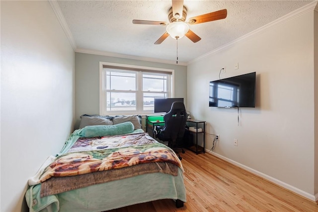 bedroom with baseboards, a textured ceiling, wood finished floors, and crown molding