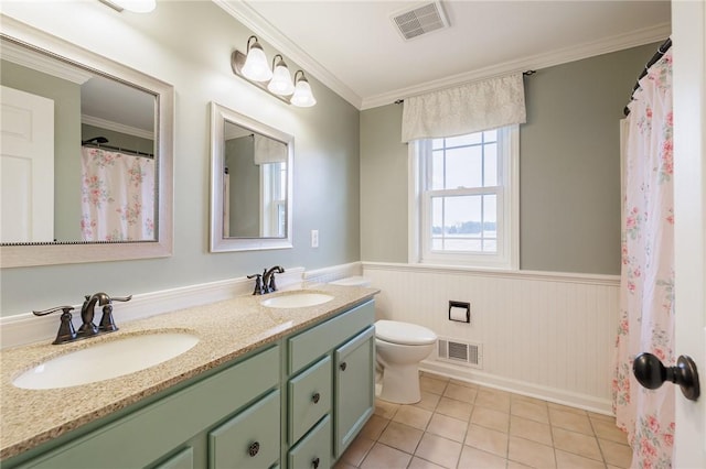 bathroom featuring visible vents, wainscoting, and a sink