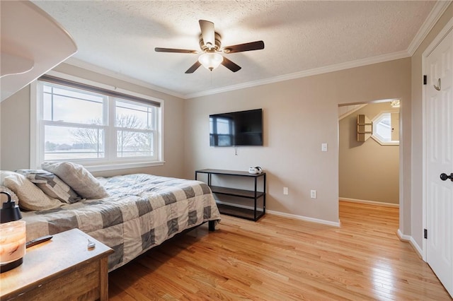 bedroom with baseboards, a textured ceiling, crown molding, and light wood finished floors