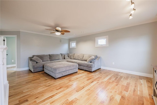 living area featuring baseboards, crown molding, and light wood finished floors