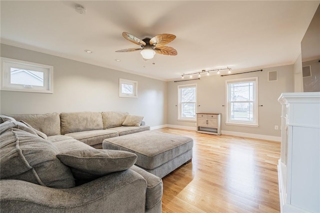 living room with light wood-type flooring, baseboards, visible vents, and ornamental molding