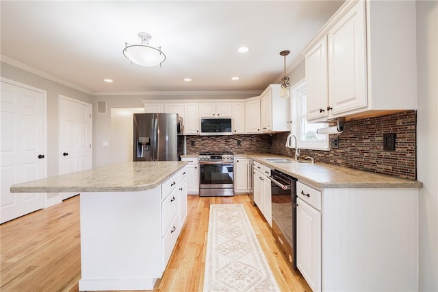 kitchen featuring light wood-type flooring, a sink, a kitchen island, white cabinetry, and stainless steel appliances